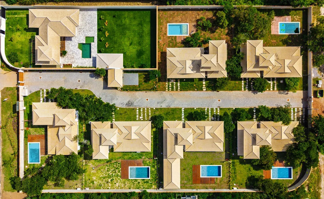 Vista de cima do Paineiras Residencial: rua interna ao centro, quatro residências de um lado e duas do outro, todas com piscina