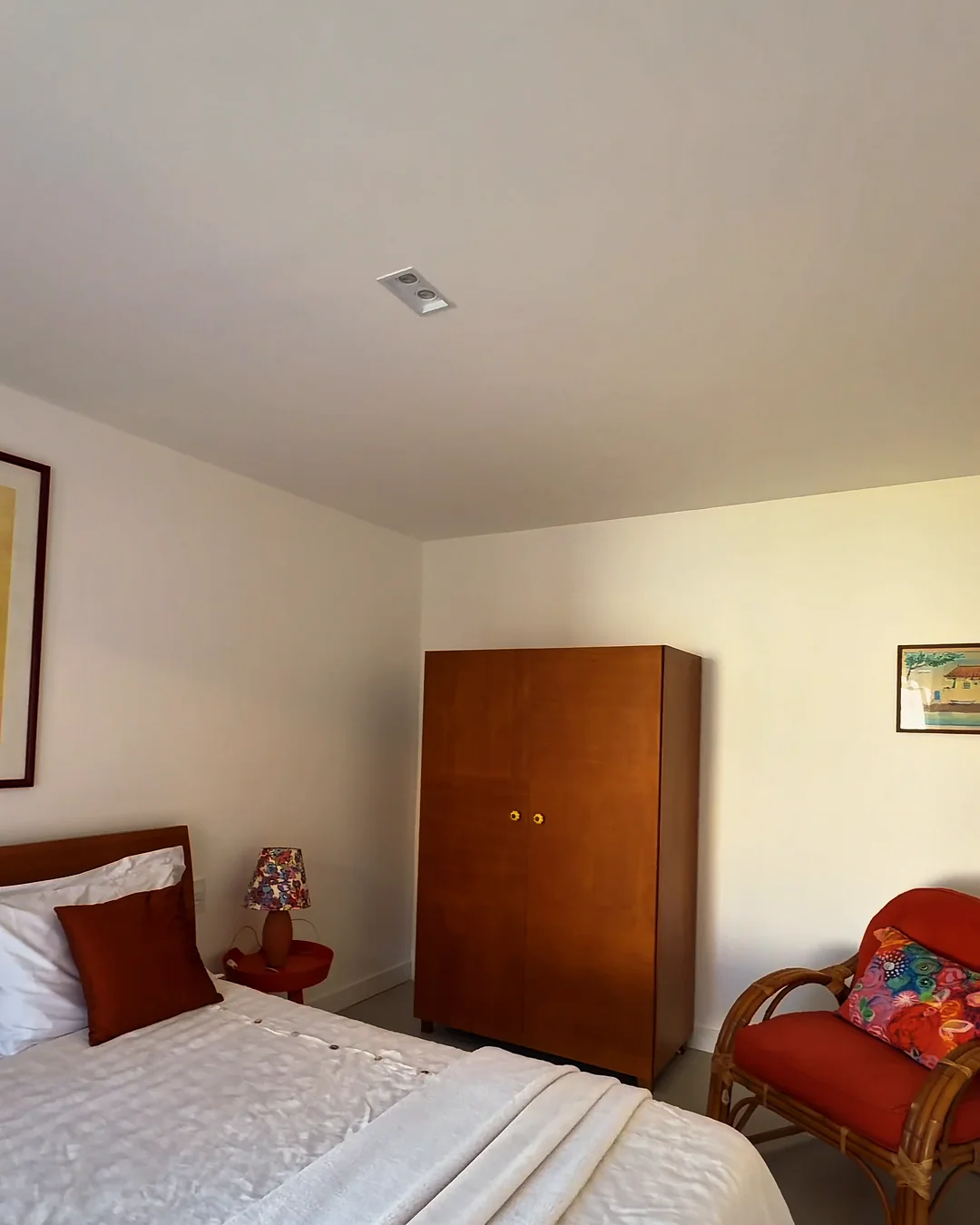 Suíte decorada com cama de casal e armário de madeira