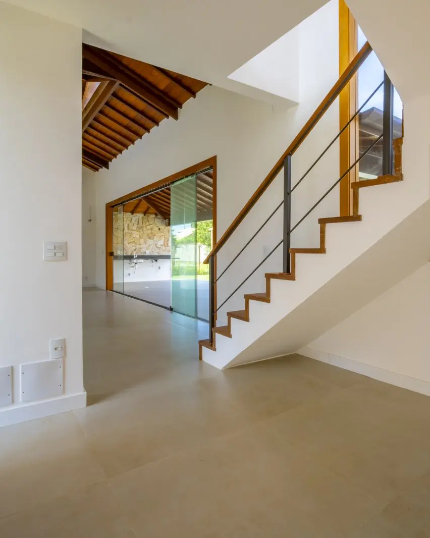 Hall de entrada com a escada e o jardim ao fundo