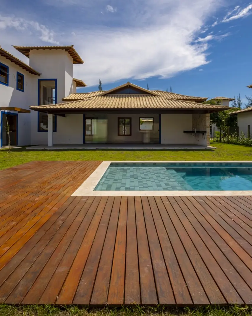 Piscina com deck de madeira no jardim da casa